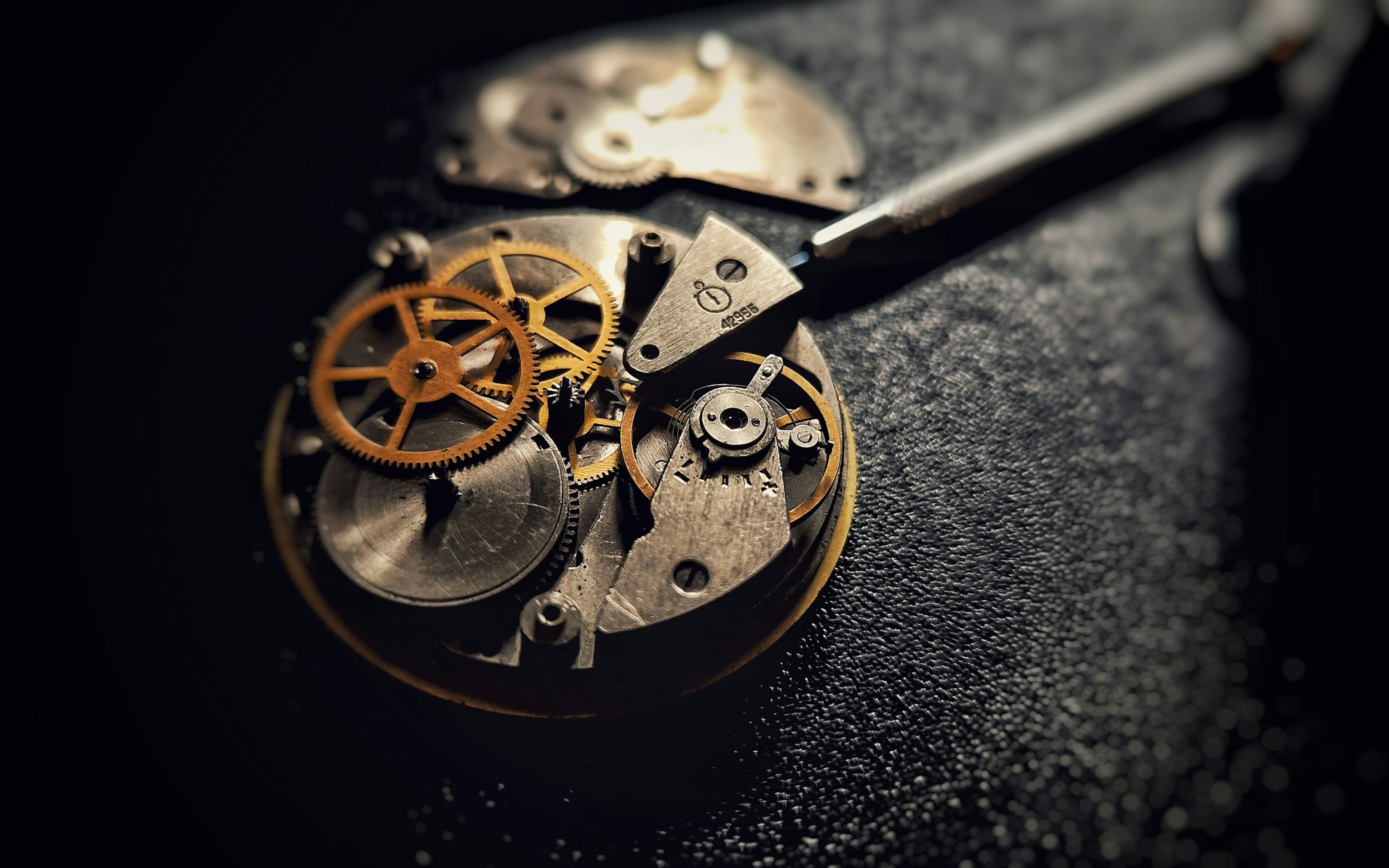 A watch movement being worked on with tweezers