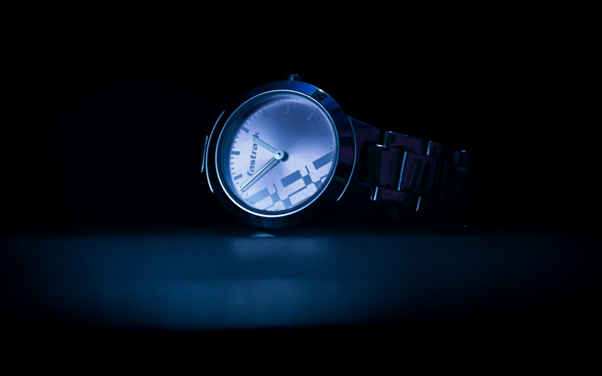 A watch glowing blue in the dark